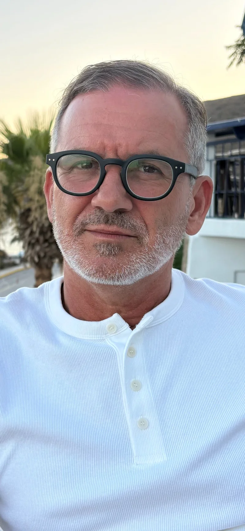 Nebojsa Visnjic outdoors, wearing black glasses and a white shirt